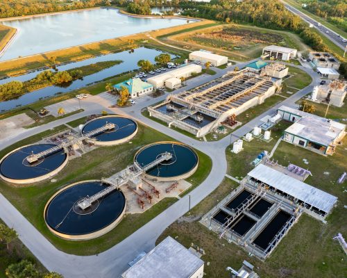 Large-scale industrial water treatment plant purifying and recycling water through filtration and chemical processes to meet health and safety standards.