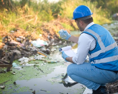 Water resource experts check the water quality in a community canal contaminated with garbage in the canal.